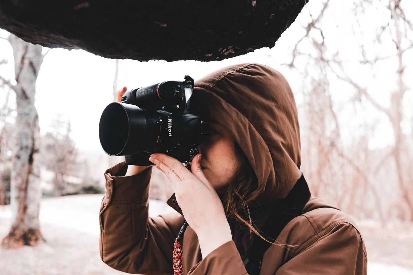 A photographer looking through her camera outdoors